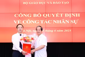 Bộ trưởng Nguyễn Kim Sơn trao Quyết định và tặng hoa chúc mừng tân Phó Vụ trưởng Vụ Giáo dục Phổ thông Nguyễn Thế Sơn.