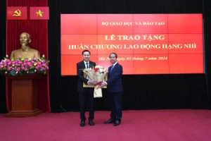 Bộ trưởng Nguyễn Kim Sơn trao Huân chương và tặng hoa chúc mừng ông Phạm Như Nghệ.