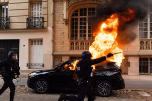Một chiếc xe bốc cháy trong cuộc biểu tình quy mô lớn tại Place d'Italie ở Paris, Pháp, ngày 13/10/2026. 