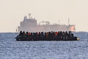 Xuồng nhỏ chở người di cư hướng về Dover, phía sau là một tàu chở hàng rời, gần Calais, Pháp, ngày 6/9/2026.