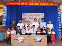 Đại diện nhà tài trợ cùng lãnh đạo chính quyền, BGH nhà trường trao quà cho học sinh.
