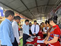 Ông Lê Thành Đô (thứ 3 tính từ bên trái) cùng các đại biểu thăm gian hàng trưng bày sản phẩm nông nghiệp của xã Chiềng Sinh.