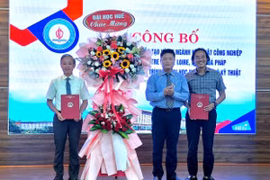 TS Bùi Văn Lợi, Phó Giám đốc Phụ trách Đại học Huế (giữa) tặng hoa chúc mừng lãnh đạo Trường Đại học Sư phạm trong lễ công bố chương trình đào tạo mới.