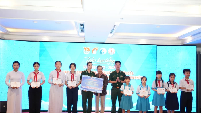 Bà Lê Minh Ngọc, Phó Chủ nhiệm CLB “Vì Hoàng Sa- Trường Sa thân yêu” trao học bổng cho đại diện Đồn Biên phòng và học sinh.