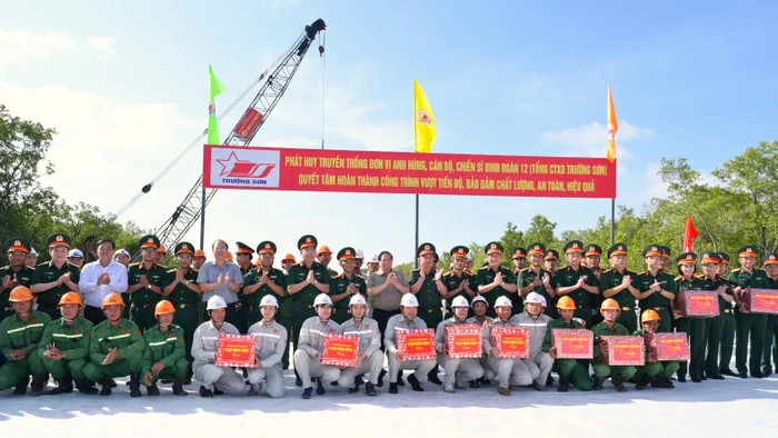 Thủ tướng Phạm Minh Chính tặng quà công nhân thi công tại điểm đầu xây dựng tuyến giao thông ra đảo Hòn Khoai. Ảnh: Tâm Đông