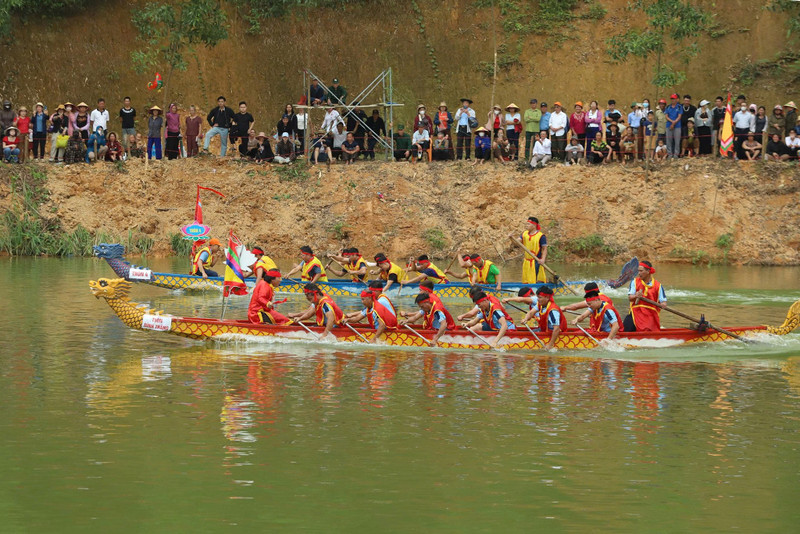 Hai bên bờ, hàng nghìn người đứng sẵn cầm cờ reo hò cổ vũ cho các đội đua. dua-thuyen-10.jpg