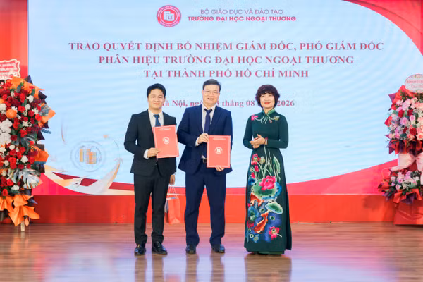 TS Nguyễn Bình Minh (giữa) nhận quyết định điều động, bổ nhiệm giữ chức vụ Giám đốc Phân hiệu Trường Đại học Ngoại thương tại TPHCM. Ảnh: NTCC.