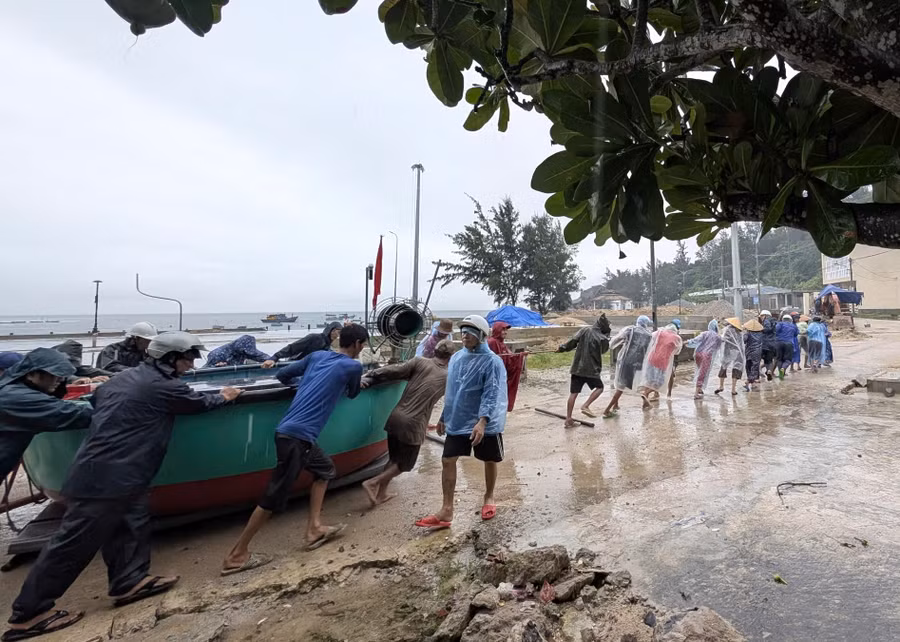 Lực lượng chức năng cùng người dân di dời tàu thuyền đến nơi an toàn.