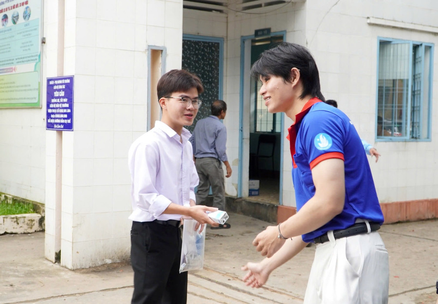 Tình nguyện viên hỗ trợ nước, sữa cho thí sinh trước khi vào điểm thi. Ảnh: Dung Nguyễn. z6742632381002-a76a4c209e02ffa2987df9a526ae0595.jpg