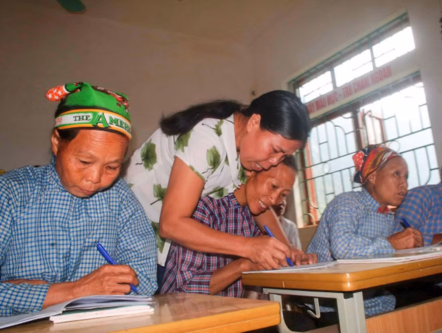 Cô giáo hướng dẫn học viên viết chữ tại lớp xóa mù chữ ở Lũng Chuống, xã Tổng Cọt, tỉnh Cao Bằng. (Ảnh: Chu Hiệu/TTXVN)