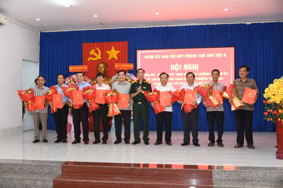 Đại tá Cao Minh Tâm, Phó Chính ủy Bộ Chỉ huy Quân sự tỉnh An Giang trao Quyết định cho các bí thư xã, phường. Ảnh: Phương Vũ.