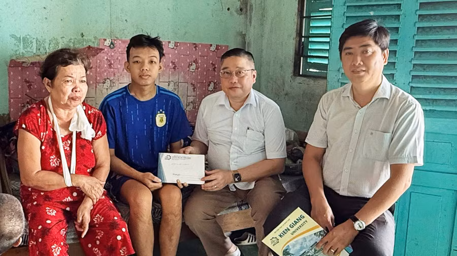 TS Nguyễn Hữu Thọ, Bí thư Đảng ủy, Chủ tịch Hội đồng Trường Đại học Kiên Giang trao tiền hỗ trợ sinh viên Tuấn Anh và gia đình.
