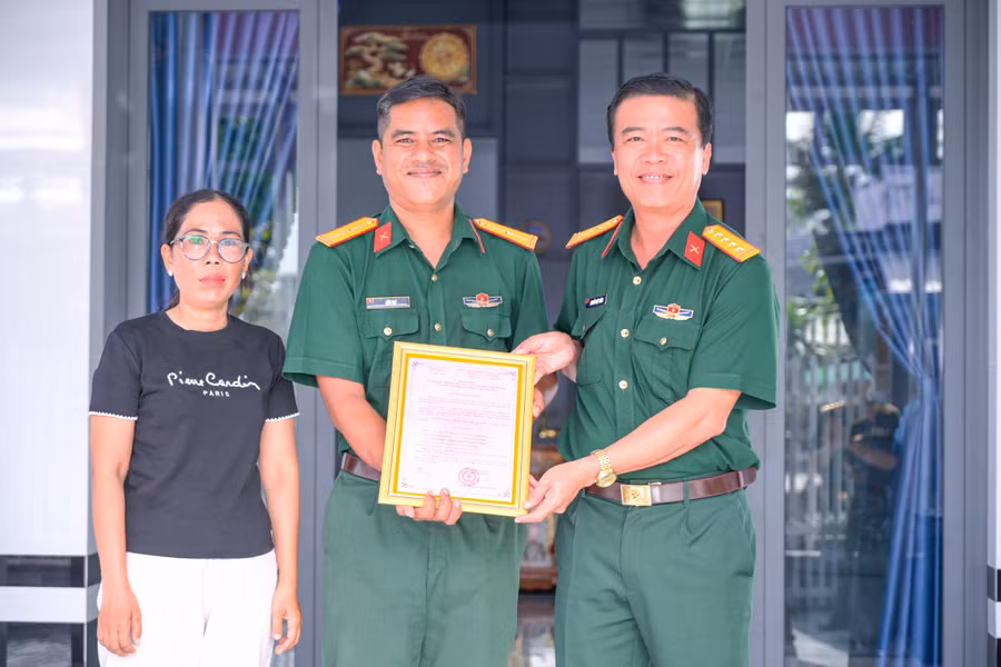 Đại tá Nguyễn Việt Thắng (phải) trao quyết định bàn giao nhà đồng đội cho gia đình Thiếu tá QNCN Liêu Đạt.