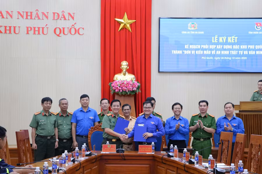 Đại tá Lê Phú Thạnh và ông Phan Duy Bằng thực hiện nghi thức ký kết phối hợp.