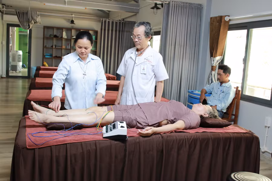 Bác sĩ Trần Thế Minh (đứng giữa) điều trị bằng phương pháp châm cứu cho bệnh nhân. (Ảnh: TT) Bác sĩ Trần Thế Minh (đứng giữa) điều trị bằng phương pháp châm cứu cho bệnh nhân. (Ảnh: TT)