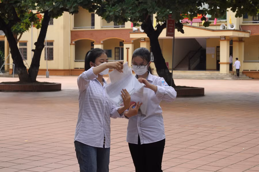Hai thí sinh cố nán lại sân trường để trao đổi về đề thi môn Ngữ văn. Hai thí sinh cố nán lại sân trường để trao đổi về đề thi môn Ngữ văn.