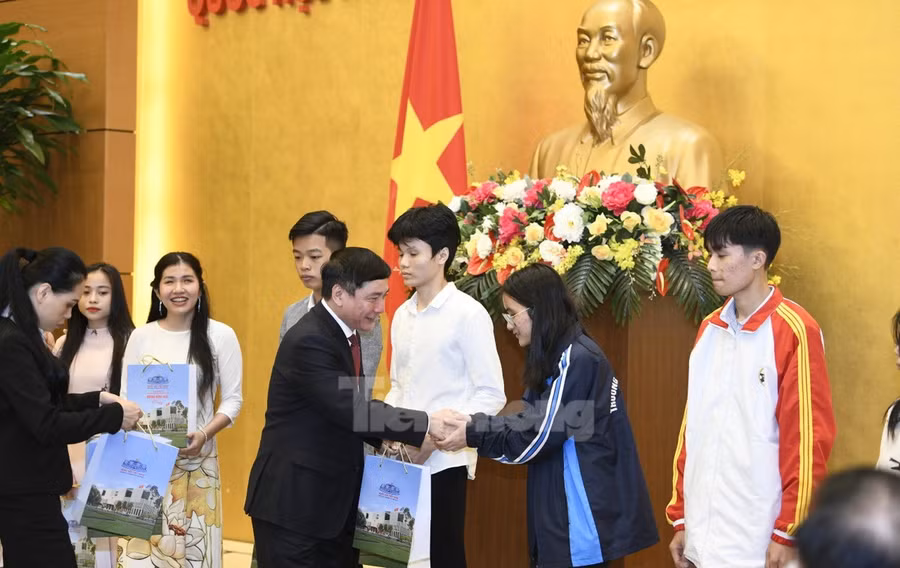 Ông Bùi Văn Cường trao quà của Chủ tịch Quốc hội cho các sinh viên.