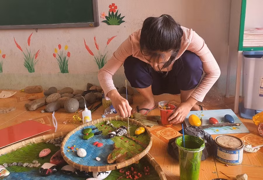 Giáo viên Trường Tiểu học xã Đăk Hà vẽ tranh trên sỏi đá.