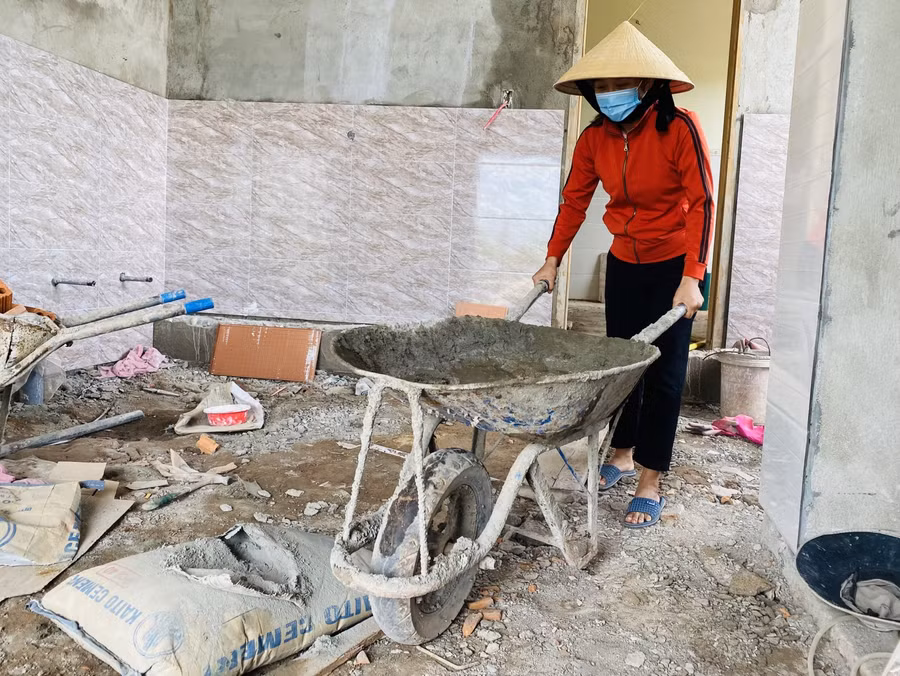 Để "tổ ấm" mơ ước sớm hoàn thiện, hết giờ dạy cô Nguyễn Thị Xuân lại làm thợ hồ giúp chồng và nhóm thợ.