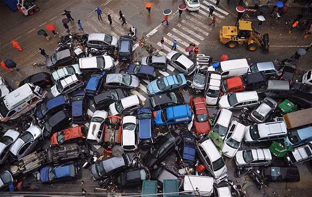 Những hình ảnh ấn tượng tuần qua ảnh 10 Cars that were swept into a pile by Friday’s torrential rains are seen on a street in Genoa. Italy’s Premier Silvio Berlusconi says poor construction in flood plains was partly to blame for devastating floods that have killed at least seven people in the port city of Genoa.