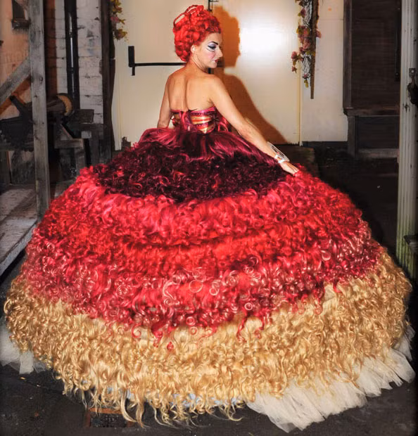 Liverpool dressmaker Thelma Madine has created a dress made entirely from human hair. The size 6 dress, which took eight people over 300 hours to complete, uses 250 metres of hair and weighs 15 stone (95kg). Eight designers from Thelma’s dress shop Nico’s Dressmakers, which featured on the Channel Four series My Big Fat Gypsy Wedding, spent 12 days making the dress. The dress with a price tag of more than £50,000 includes 1500 crystals and 12 underskirts.