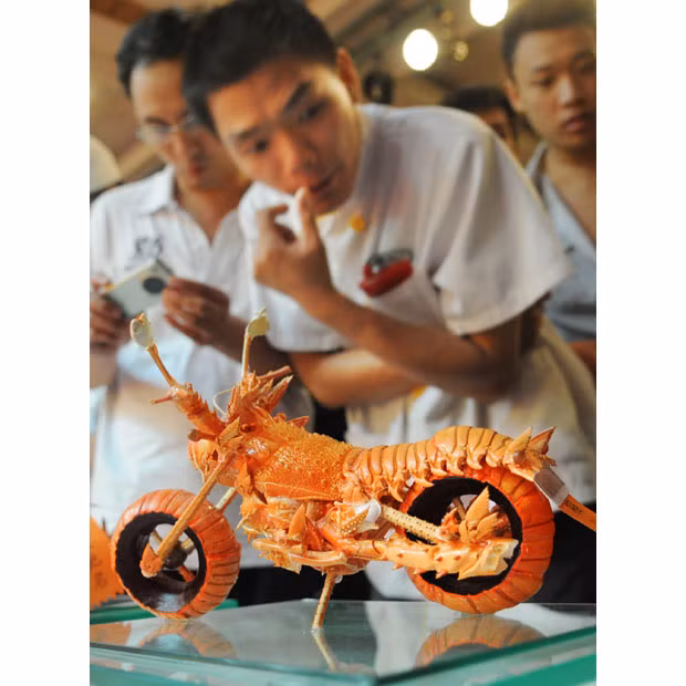 Taiwanese chef Huang Mingbo shows off a motorcycle which made from five lobster shells in Fuzhou, Fujian Province, China