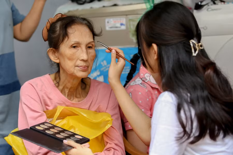 Các tình nguyện viên có mặt từ khá sớm trang điểm, làm tóc cho các cụ, các bà ngay tại xóm ve chai.