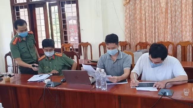 Vương Quốc Thịnh (áo trắng) làm việc tại cơ quan công an. Ảnh: Kiều Anh.