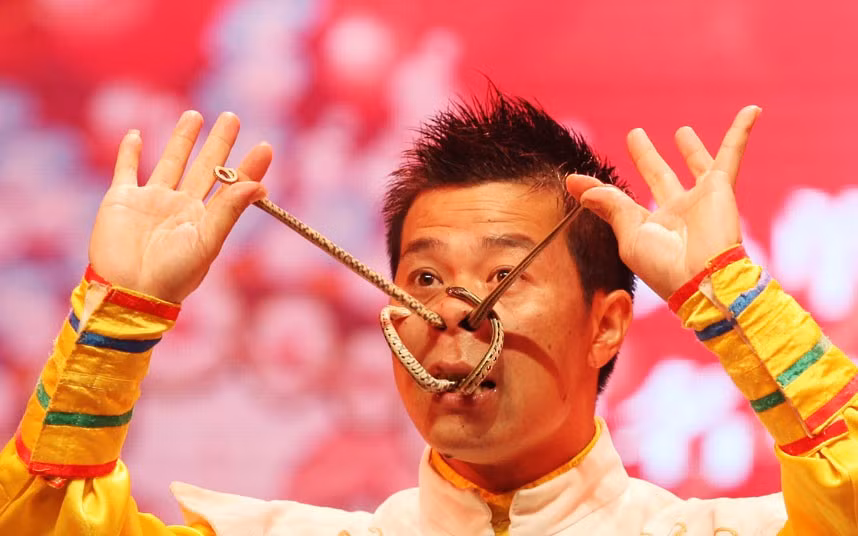 Những hình ảnh ấn tượng trong tuần ảnh 6 Stunt performer Liu Hong winds snakes through his nose and mouth at a folk artist stunt competition in Yongchun, Chongqing Municipality, China
