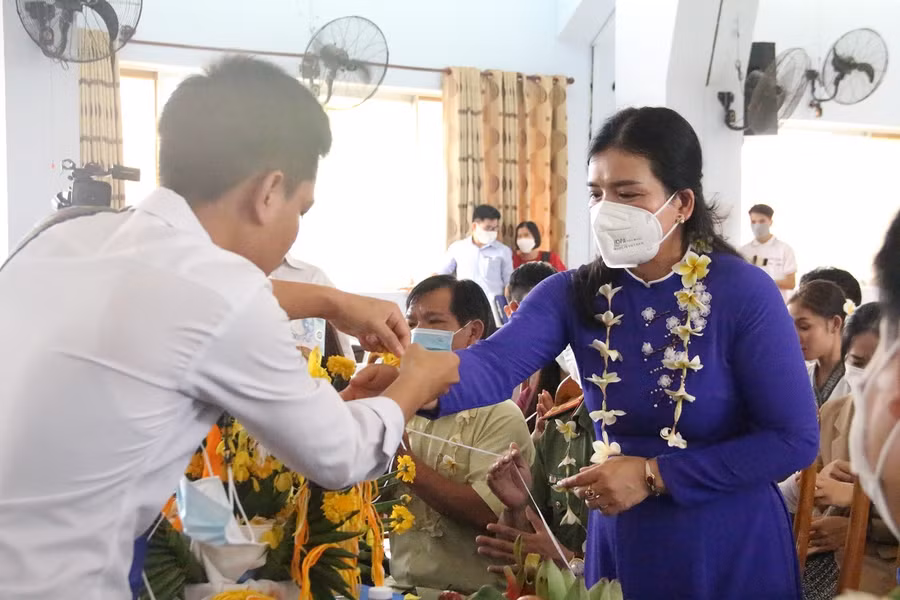 Lưu học sinh Lào đeo chỉ cổ tay để gửi lời chúc và cầu mong may mắn đến bà Y Ngọc, Phó chủ tịch UBND tỉnh Kon Tum.