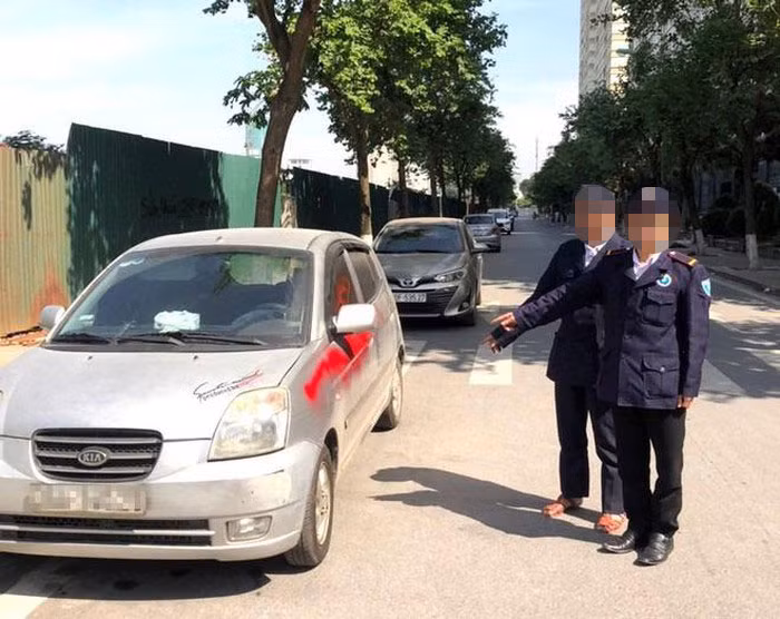 Bảo vệ chung cư CT7 Dương Nội có hành vi xịt sơn lên nhiều xe ô tô. Ảnh: CAND.