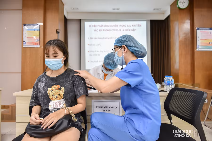 Trong lúc ngồi tại phòng chờ, Ban tổ chức tiêm đã bố trí cán bộ hướng dẫn, lưu ý người dân điền đầy đủ thông tin vào phiếu đăng ký tiêm.