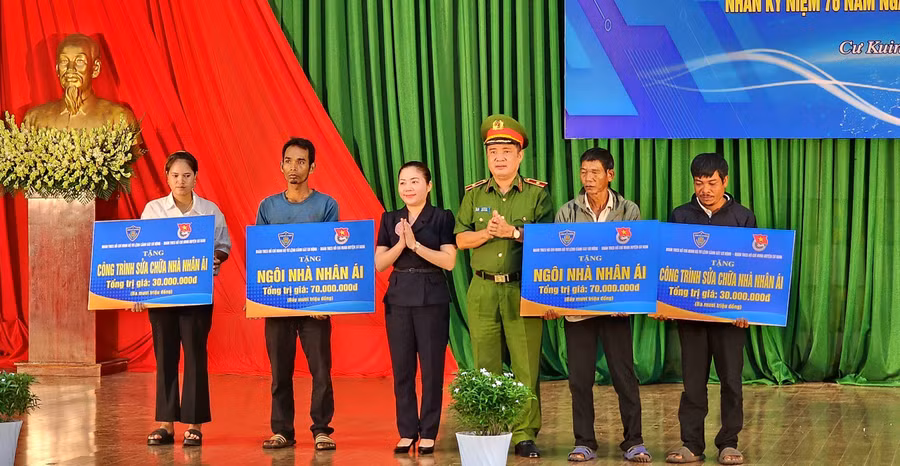Ban tổ chức trao tặng biển tượng trưng các công trình xây mới, sửa chữa nhà cho các đối tượng chính sách tại huyện Cư Kuin (ảnh: TT).