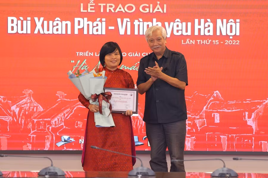 Nhà sử học Dương Trung Quốc trao giải Tác phẩm - Vì tình yêu Hà Nội cho tác giả Nguyễn Thị Thu Hòa, tác giả của cuốn sách Tranh dân gian Kim Hoàng. Ảnh: Báo Tin Tức.