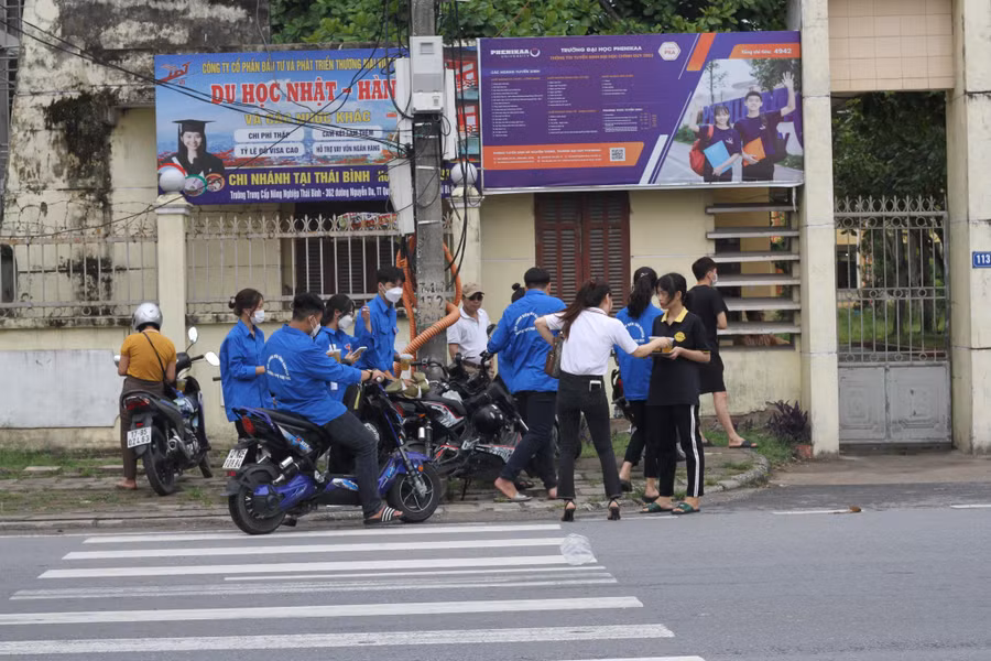 Các thành viên trong nhóm của anh Hùng trao những cốc trà chanh miễn phí tới lực lượng tình nguyện tại điểm thi trường THPT Phụ Dực.
