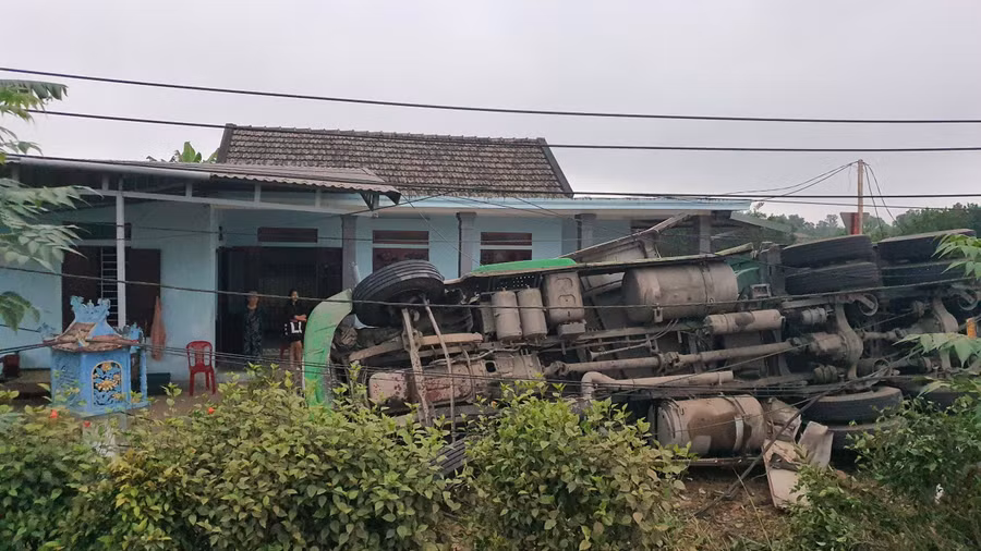 Sau khi đâm vào trụ điện, xe container lật nghiêng ngay trước nhà dân.
