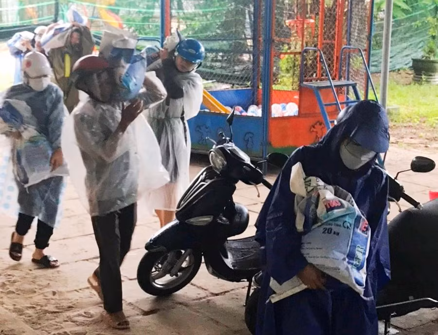 Thầy cô giáo khẩn trương vác bao cát đi chằng chống các điểm dễ bị gió bão tác động.