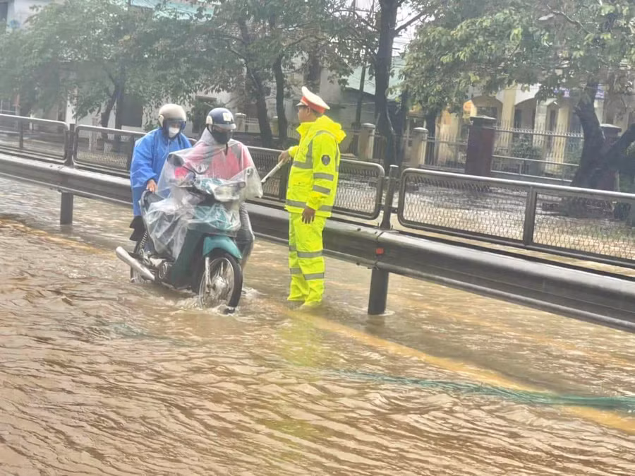 Người dân đi xe máy được CSGT hướng dẫn tắt máy, dắt qua dòng nước ở những đoạn thấp để nước lũ không vào ống pô gây chết máy xe. Người dân đi xe máy được CSGT hướng dẫn tắt máy, dắt qua dòng nước ở những đoạn thấp để nước lũ không vào ống pô gây chết máy xe.