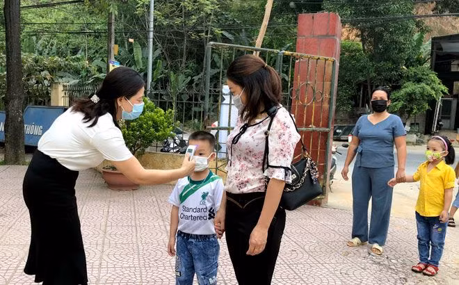 Kiểm tra thân nhiệt học sinh trước khi bước vào trường.