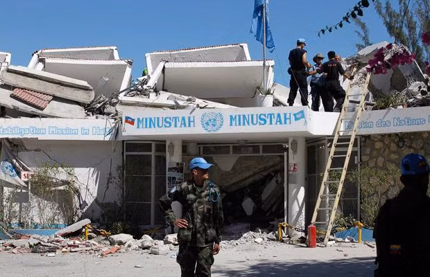 UN personnel check damage to the organisation’s headquarters in Port-au-Prince. Several bodies have been recovered from the wreckage of the building