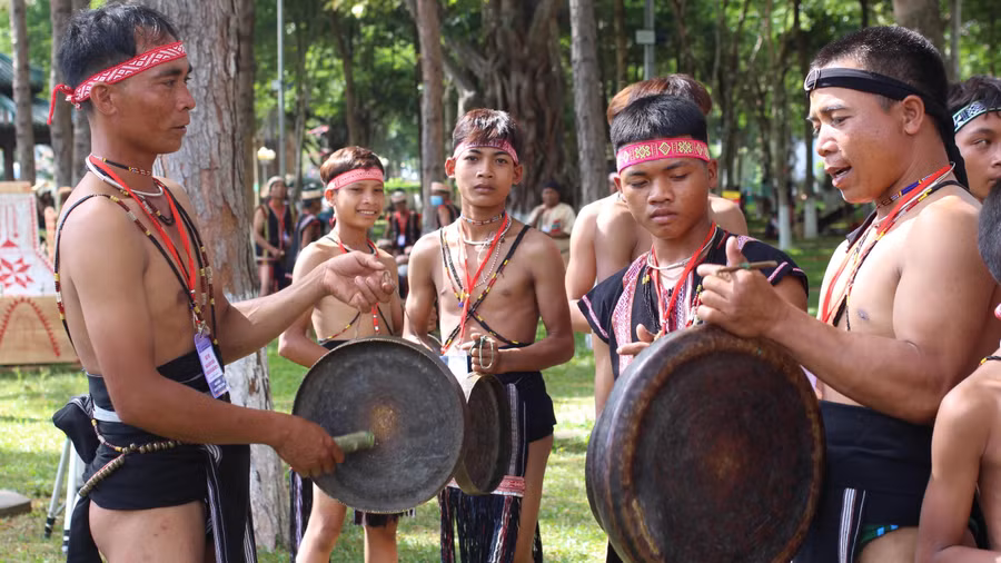 Anh Đinh A Lênh (bên trái) hướng dẫn các em nhỏ đánh chiêng.