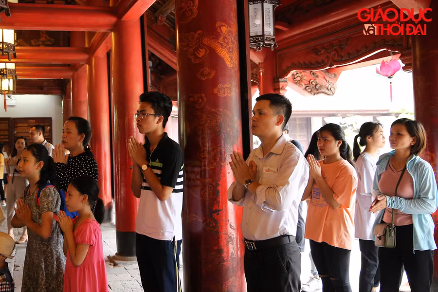Theo ghi nhận, dù đã 12 giờ trưa, dưới thời tiết nắng nóng nhưng nhiều sĩ tử không quản ngại vẫn thành tâm đứng cầu nguyện mong nhận được sự may mắn của các bậc hiền nhân