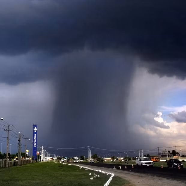 Những hình ảnh ấn tượng trong tuần ảnh 2 A heavy rain shower in the distance looks almost like a mushroom cloud. Brazilian photographer Washington Fidelis Clay Lara captured the summer rain storm on a busy road in Curitiba, Brazil.