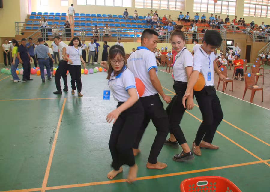 Các thầy, cô tham gia trò chơi dùng lưng đưa bóng vào rổ để cứu trợ thí sinh của mình.