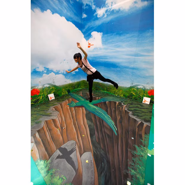 A girl poses on a 3D chalk drawing in an exhibition entitled 