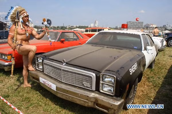 A model stands next to a vehicle during the Exhibition of Autoexotica 2010 at the Tushino airport in the suburbs of Moscow, Russia, July 10, 2010.
