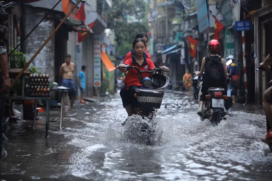 Thời điểm cuối giờ chiều, vào thời gian tan học nhiều học sinh phải lội qua điểm úng ngập để đi về nhà.