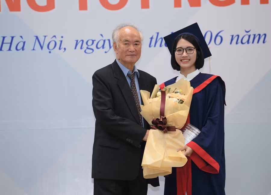 Tân cử nhân Nguyễn Bích Ngọc đại diện cho sinh viên nhận bằng tốt nghiệp tặng hoa nhà trường.