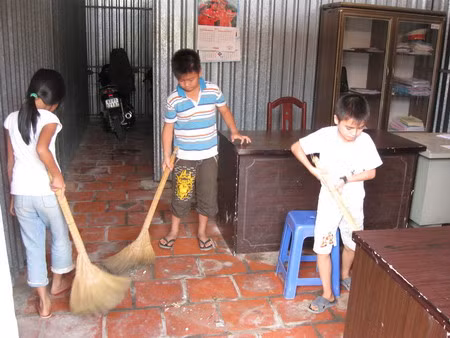 Các cháu quét dọn nhà cửa.