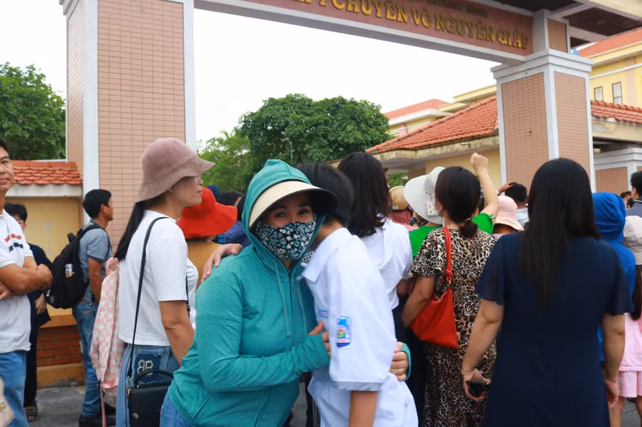 Đưa con đến điểm thi từ sớm, dù thời tiết oi ả, song nhiều phụ huynh vẫn nán lại điểm thi để kịp thời nắm bắt kết quả của con mình.